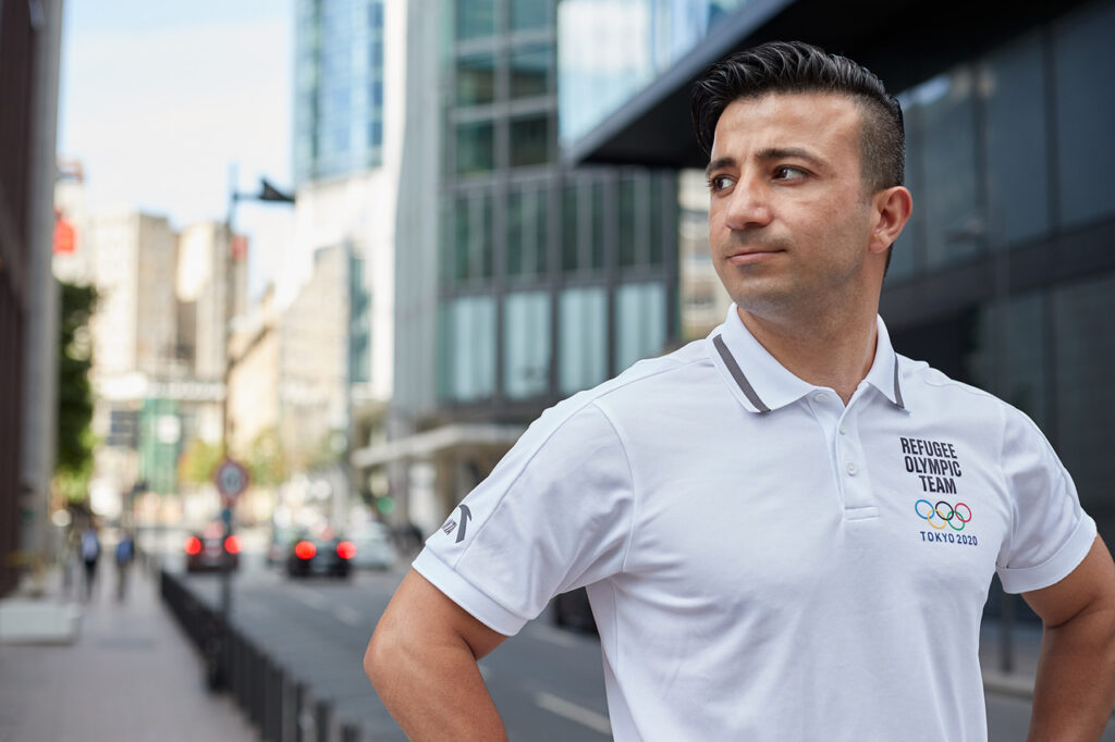 Wael Shueb schaut zur Seite in der Stadt, weißes Poloshirt vom Olympiateam.